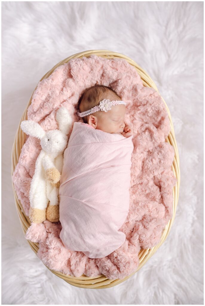 Indoor Waterloo Ontario newborn session with Millie snuggled in fluffy pink blankets and her favourite bunny stuffie